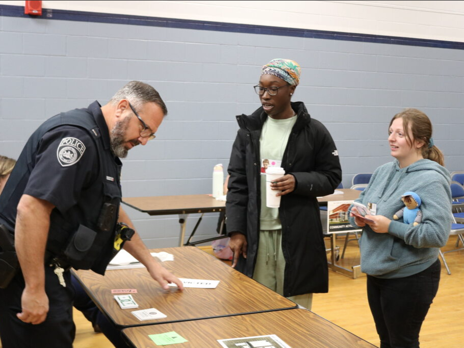 Students talk to a police officer at a table