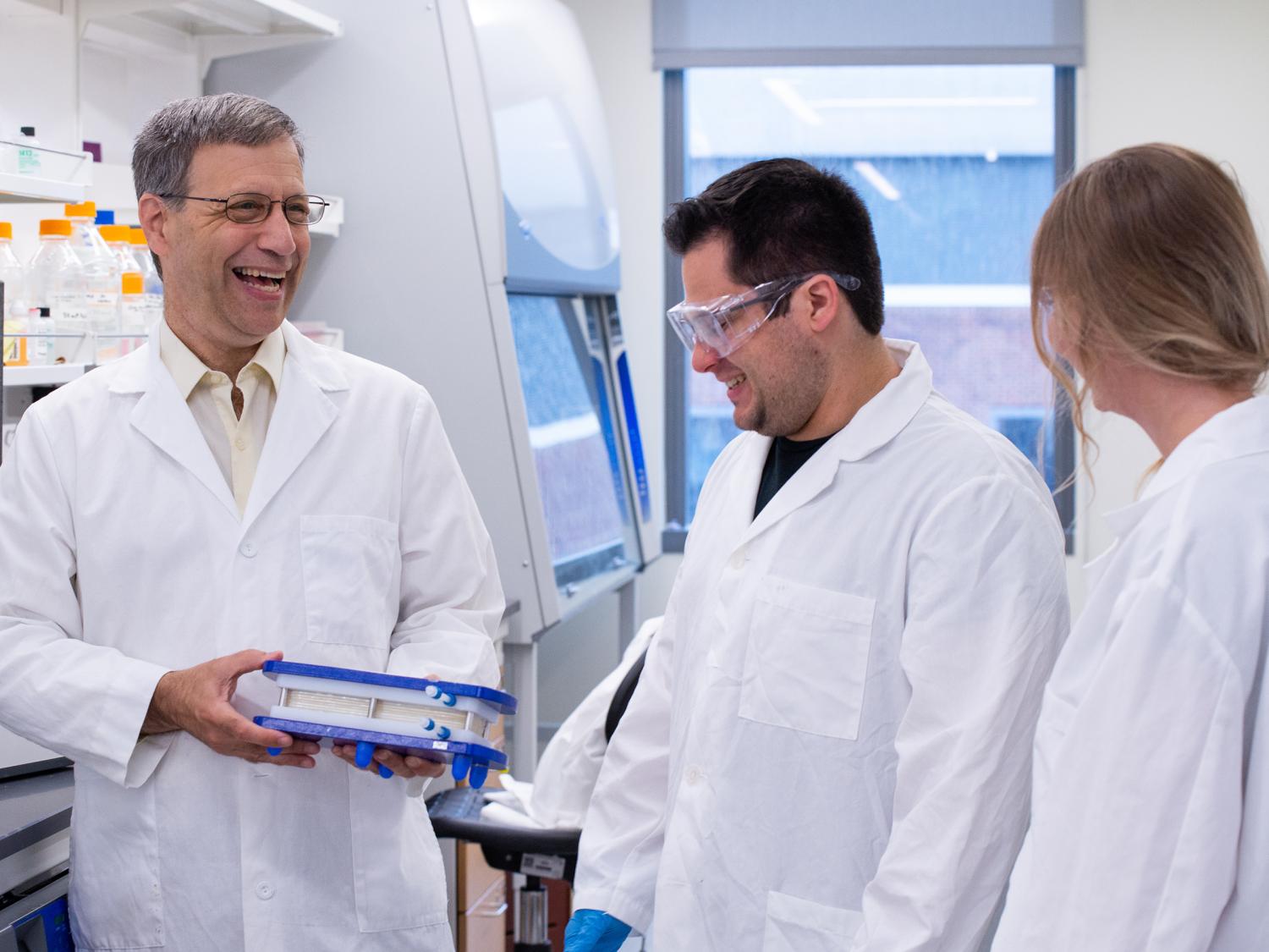 Three people conversing in a lab