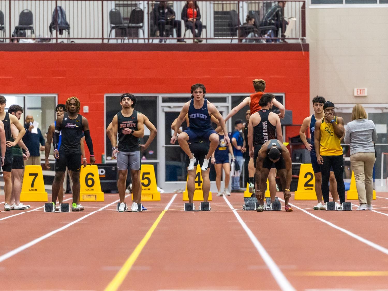 Penn State Behrend sprinter Carter Tobin stretches at the starting line before an indoor race.