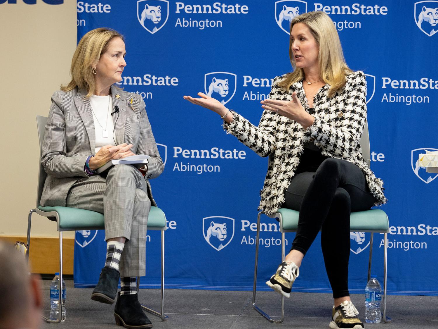 Two women sitting on stage and talking
