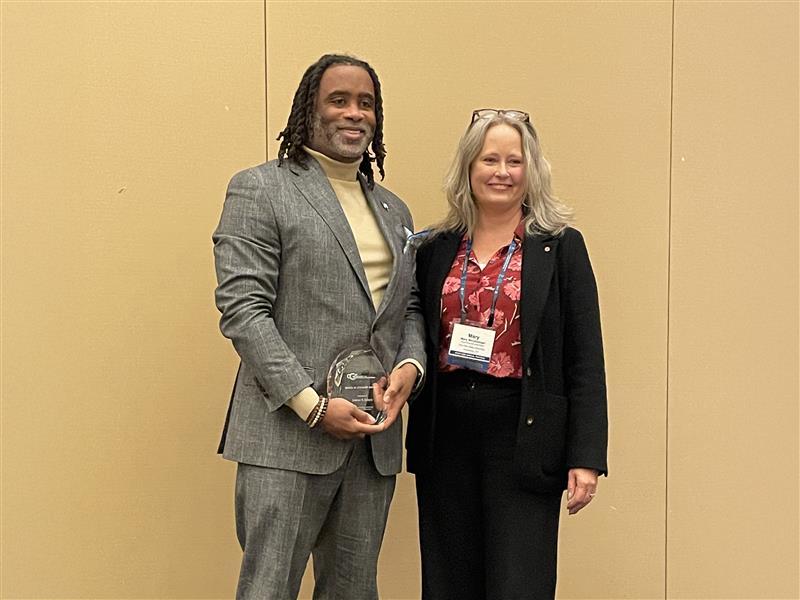 Levon Esters stands with Mary Stromberger, (title...), after receiving the Debra W. Stewart award from the Council of Graduate Schools. 
