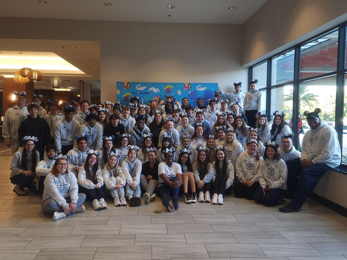 A large group of Penn State New Kensington students, faculty, and staff pose together in the lobby of a hotel.