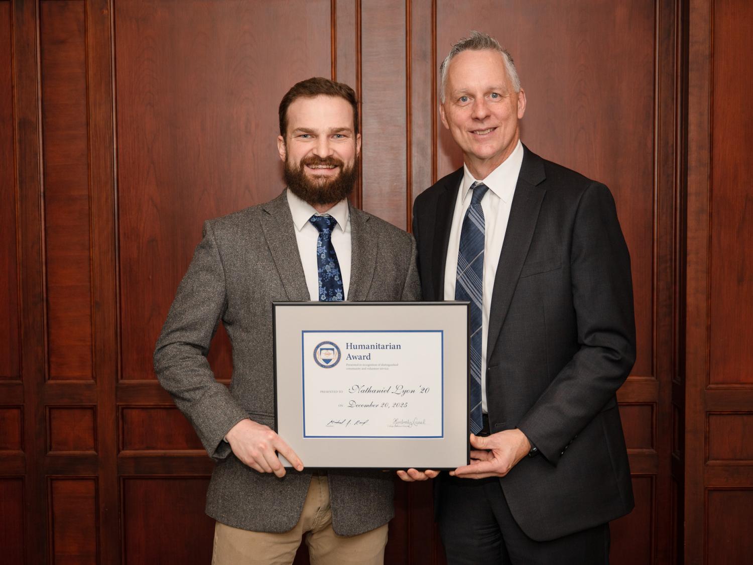 Two people holding an award