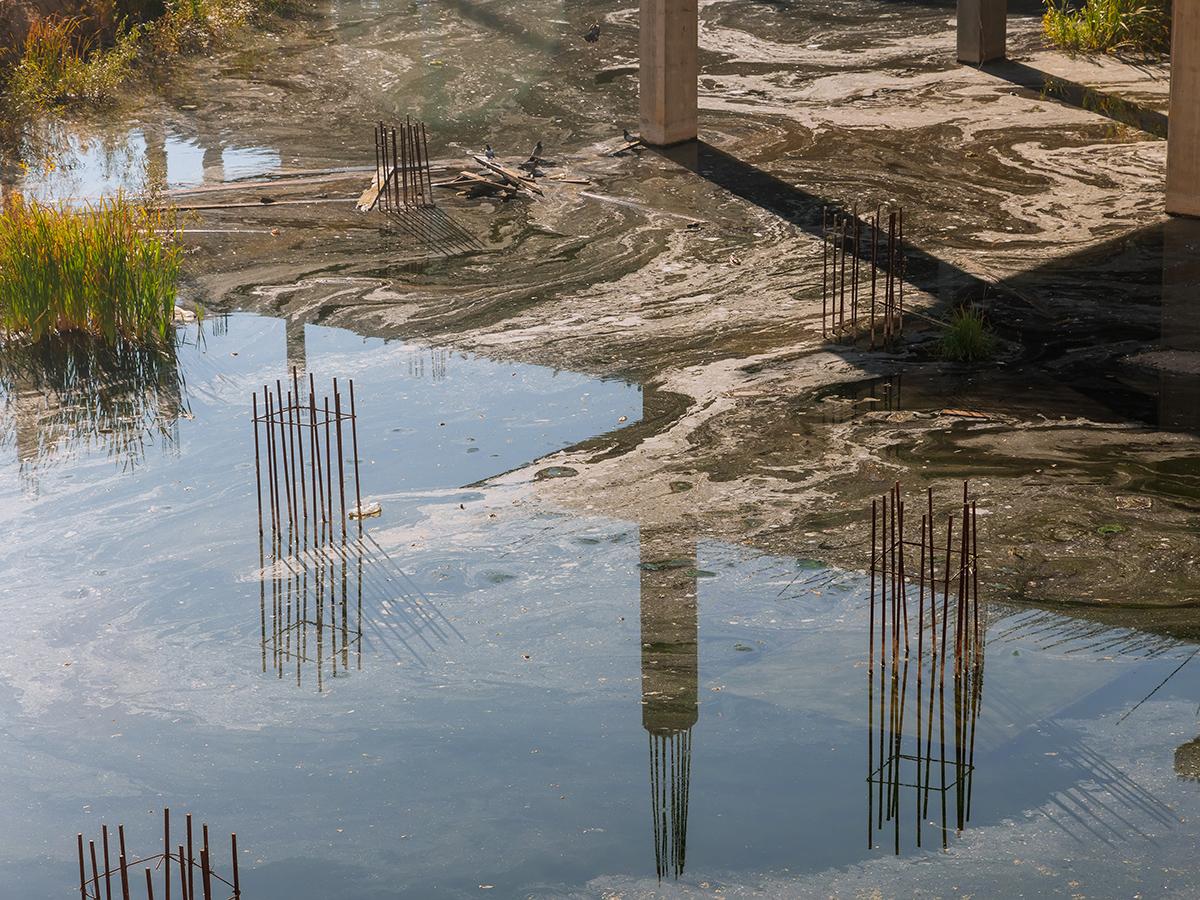 A large puddle of standing water on a dirt construction site
