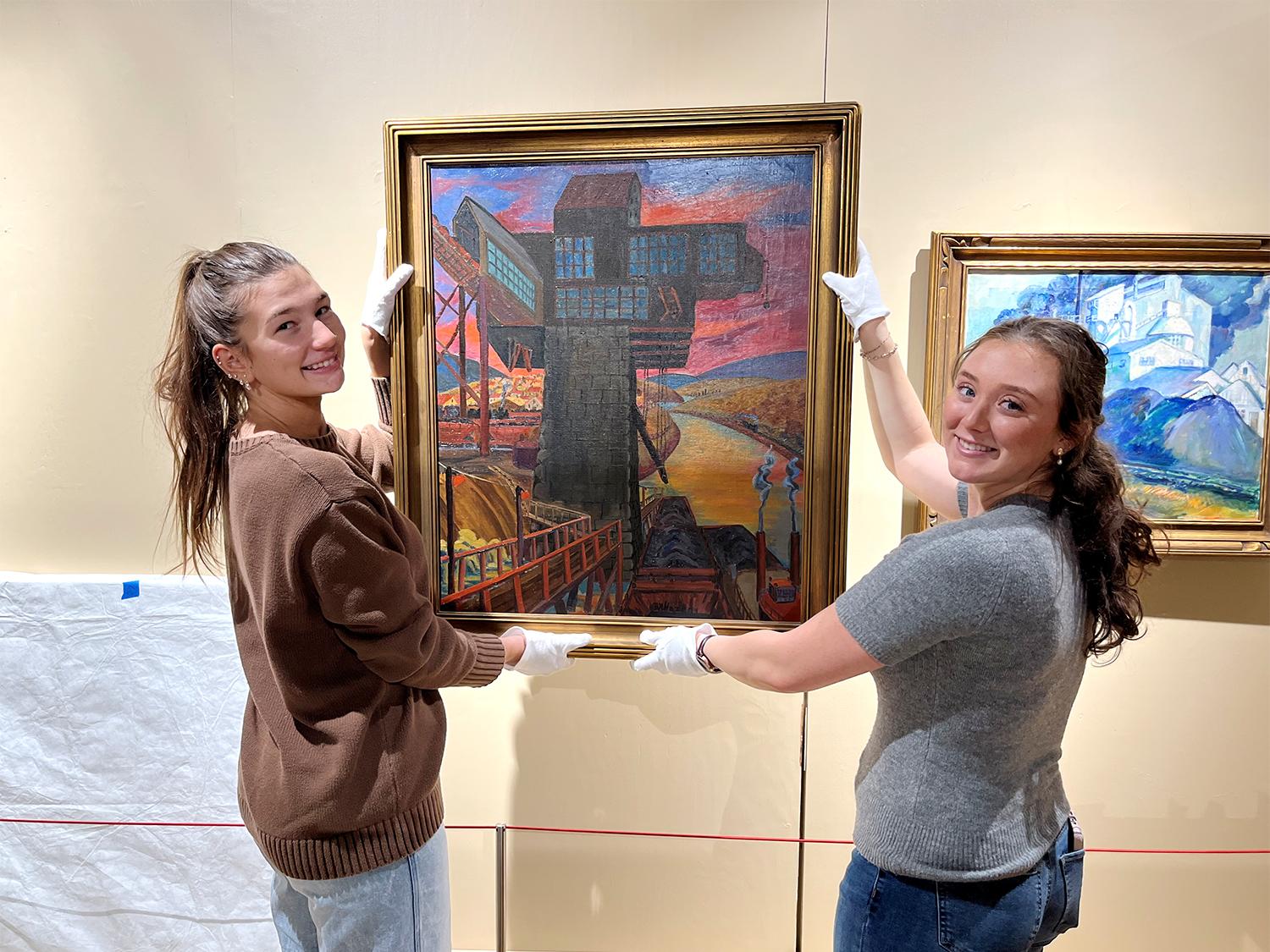 Gabriella Heidorn and Alexis Woodring hangin painting