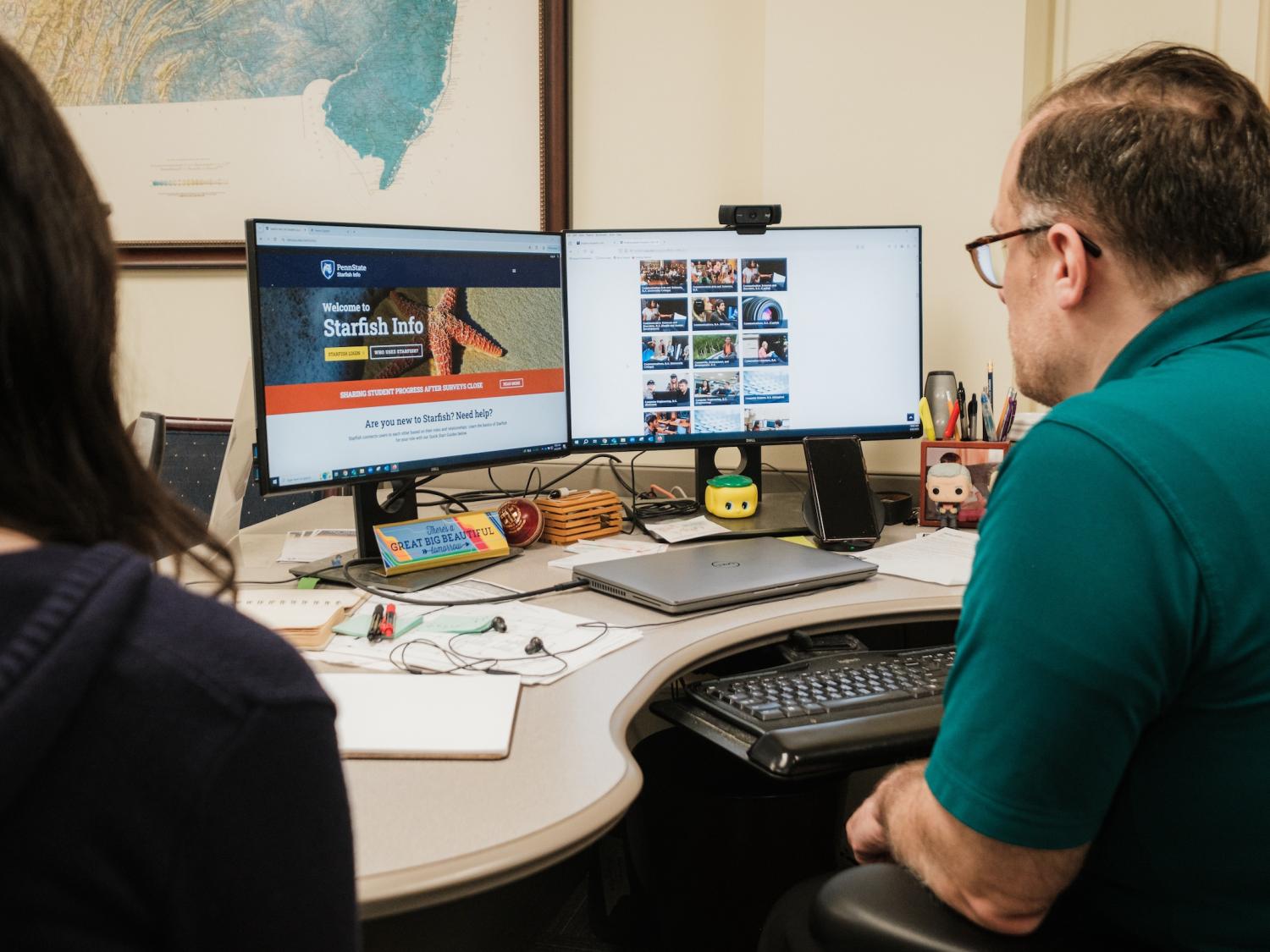 Adviser and student looking at computer
