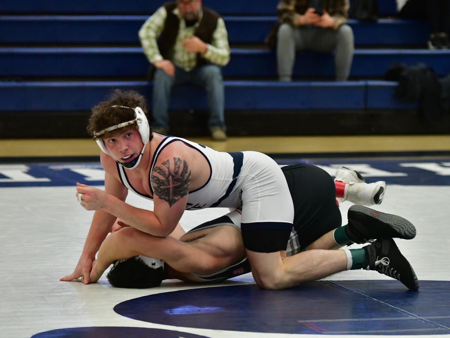 A Penn State Behrend wrestler crouches on top of an opponent.