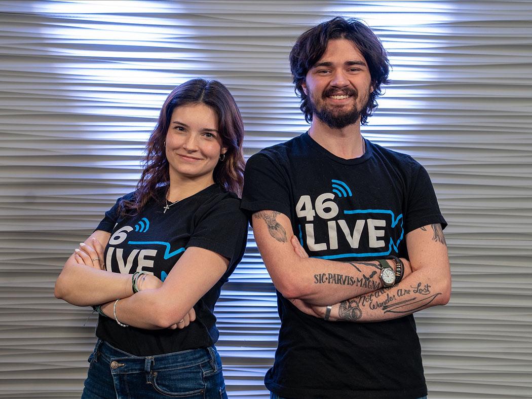 Two students side by side, arms crossed, wearing black T-shirts.