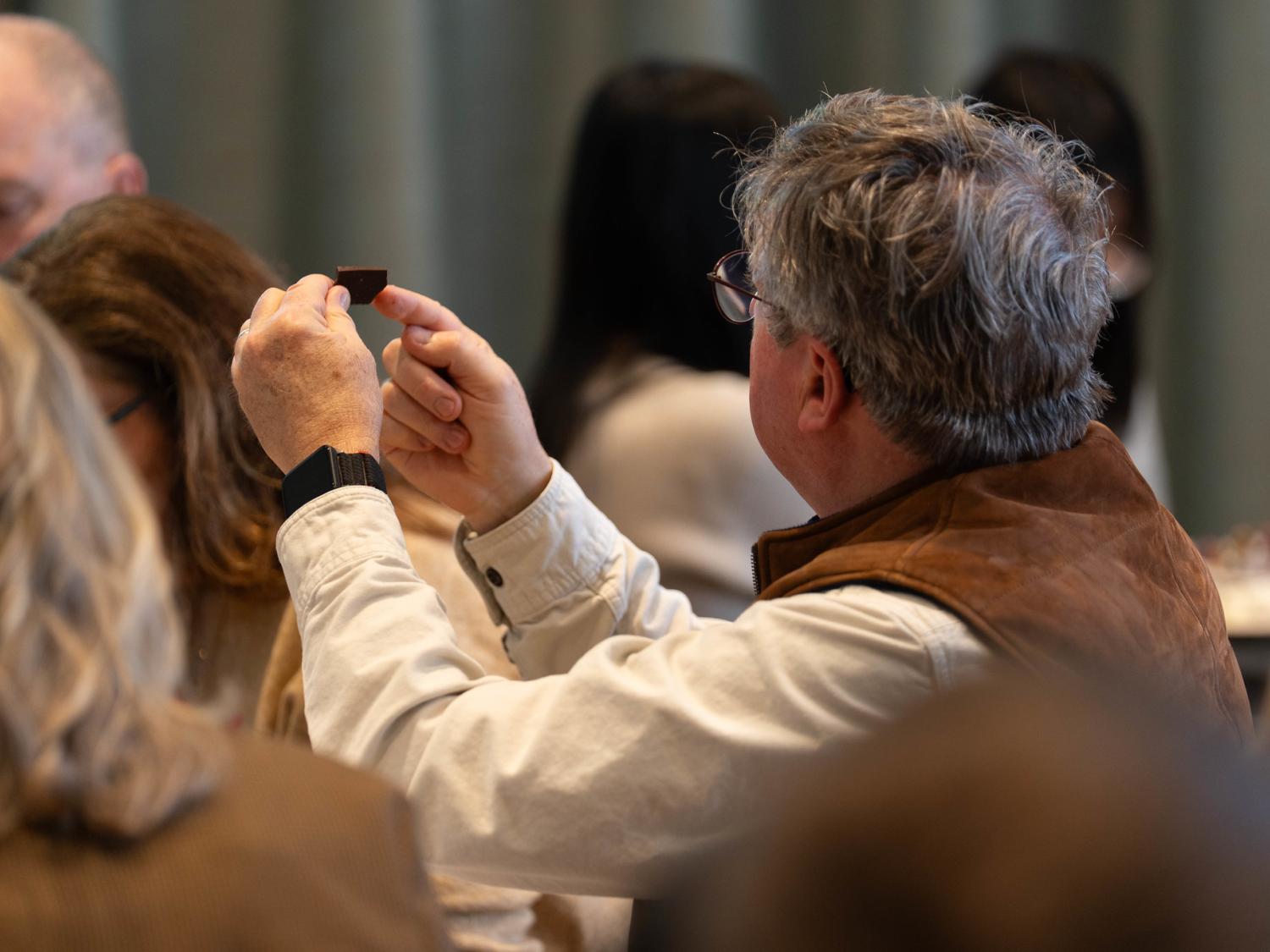 A man points to a small piece of chocolate