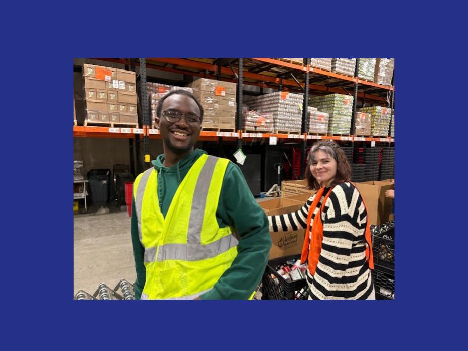 Students wearing high visibility vests put food from boxes into milk crates