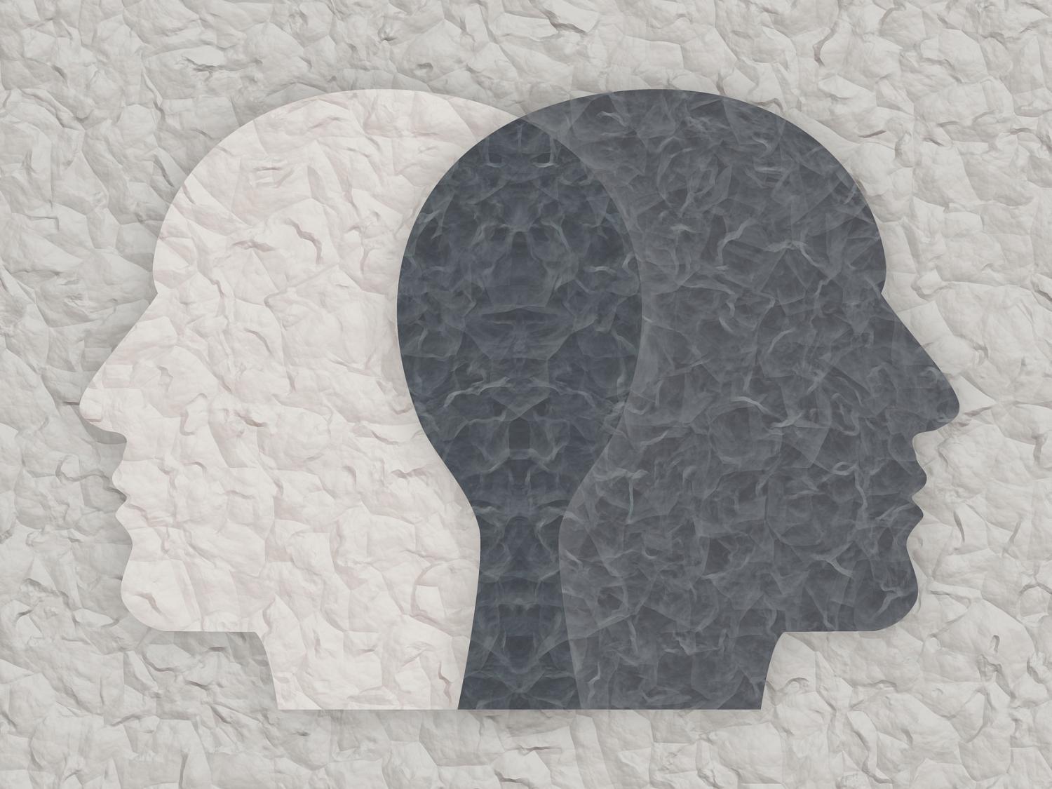 Silhouettes of two heads, one white and one dark grey.