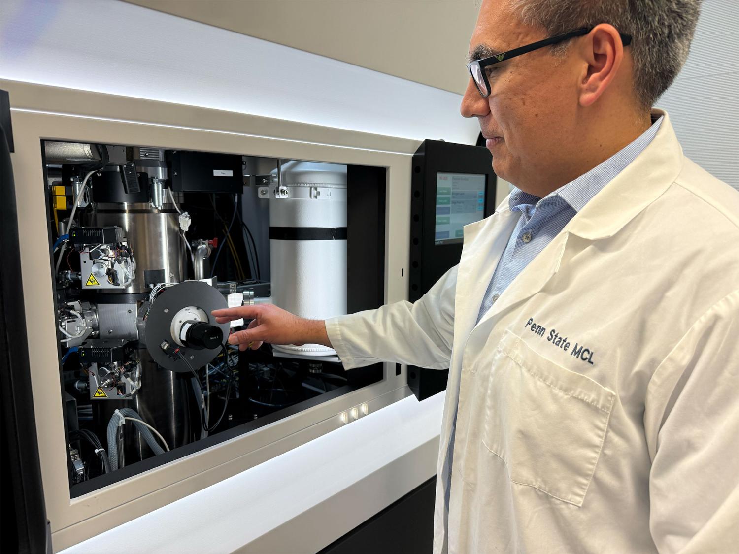Enrique Gomez stands in a lab testing a sample in a cyrogenic-electron microscope