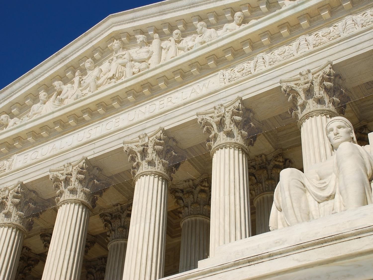 A statue outside the Supreme Court building in Washington, DC, with the building's facade in the background.