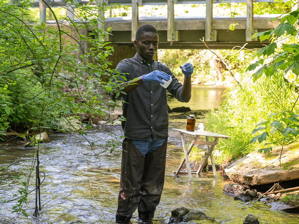 Person collecting samples in a stream