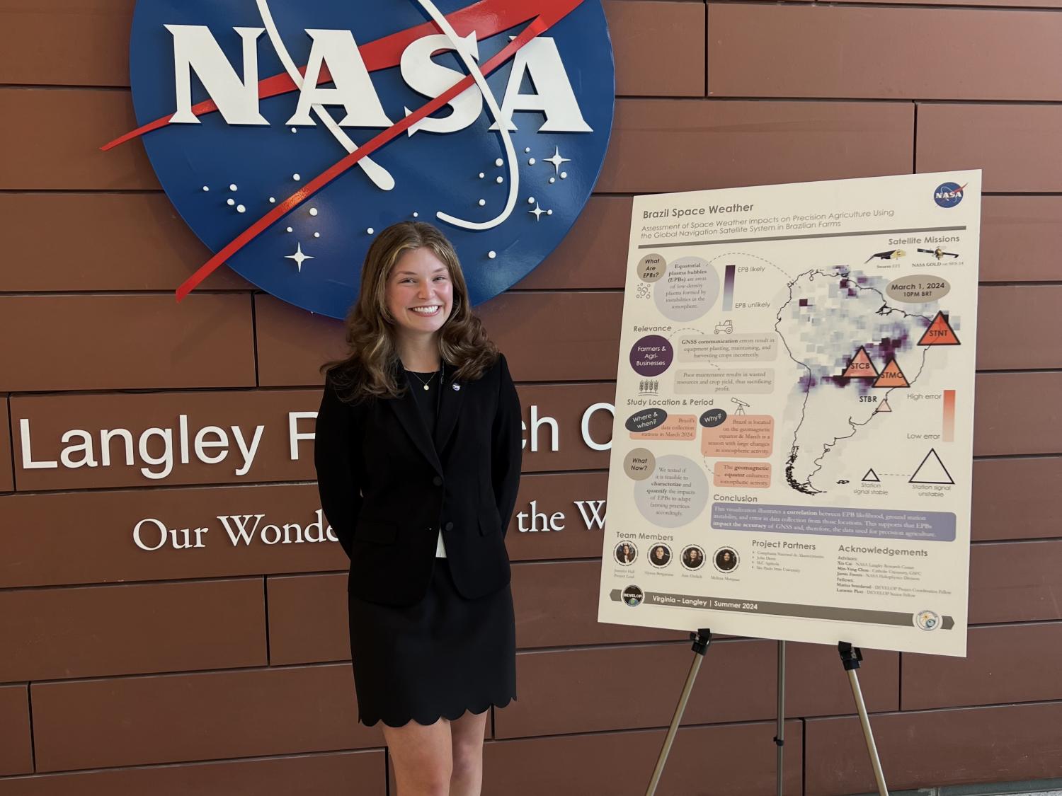 Scholar Ann Ehrlich poses in front of the NASA sign