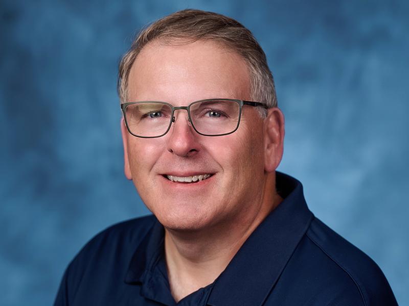 Portrait of David Lee wearing glasses and a dark blue shirt, facing slightly to the left.