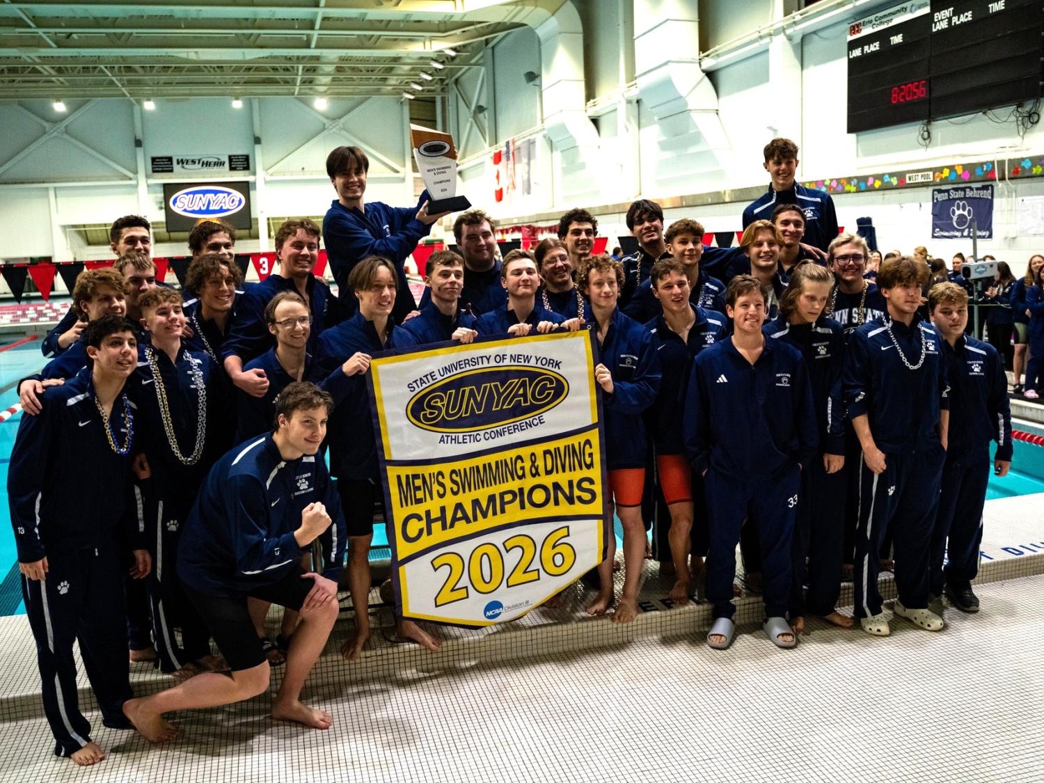 The Penn State Behrend men's swimming and diving team posts with the SUNYAC championship banner.