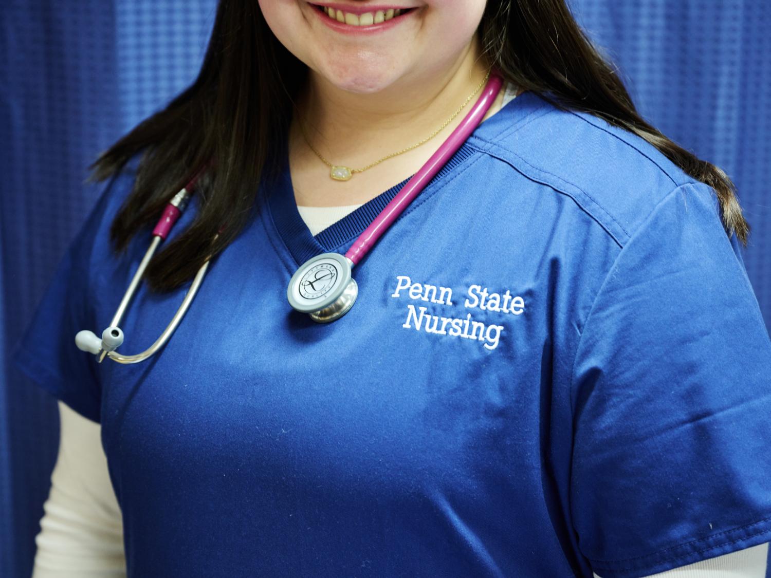 Nurse wearing a stethoscope and scrubs that say Penn State Nursing