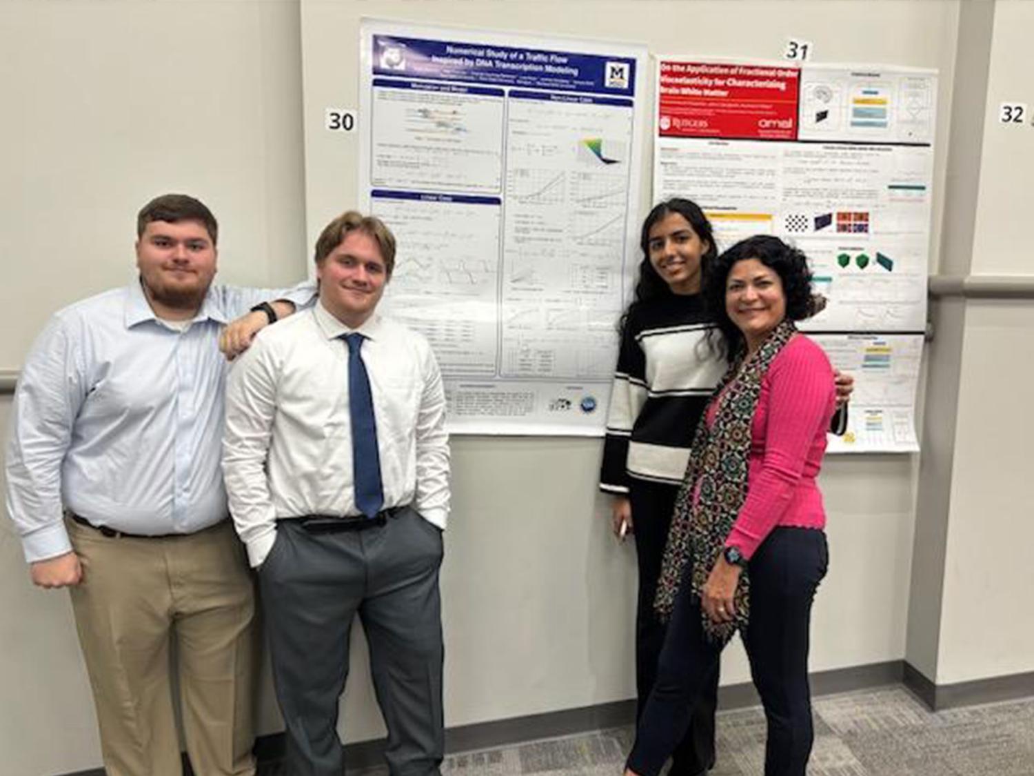 Four people standing in front of a poster