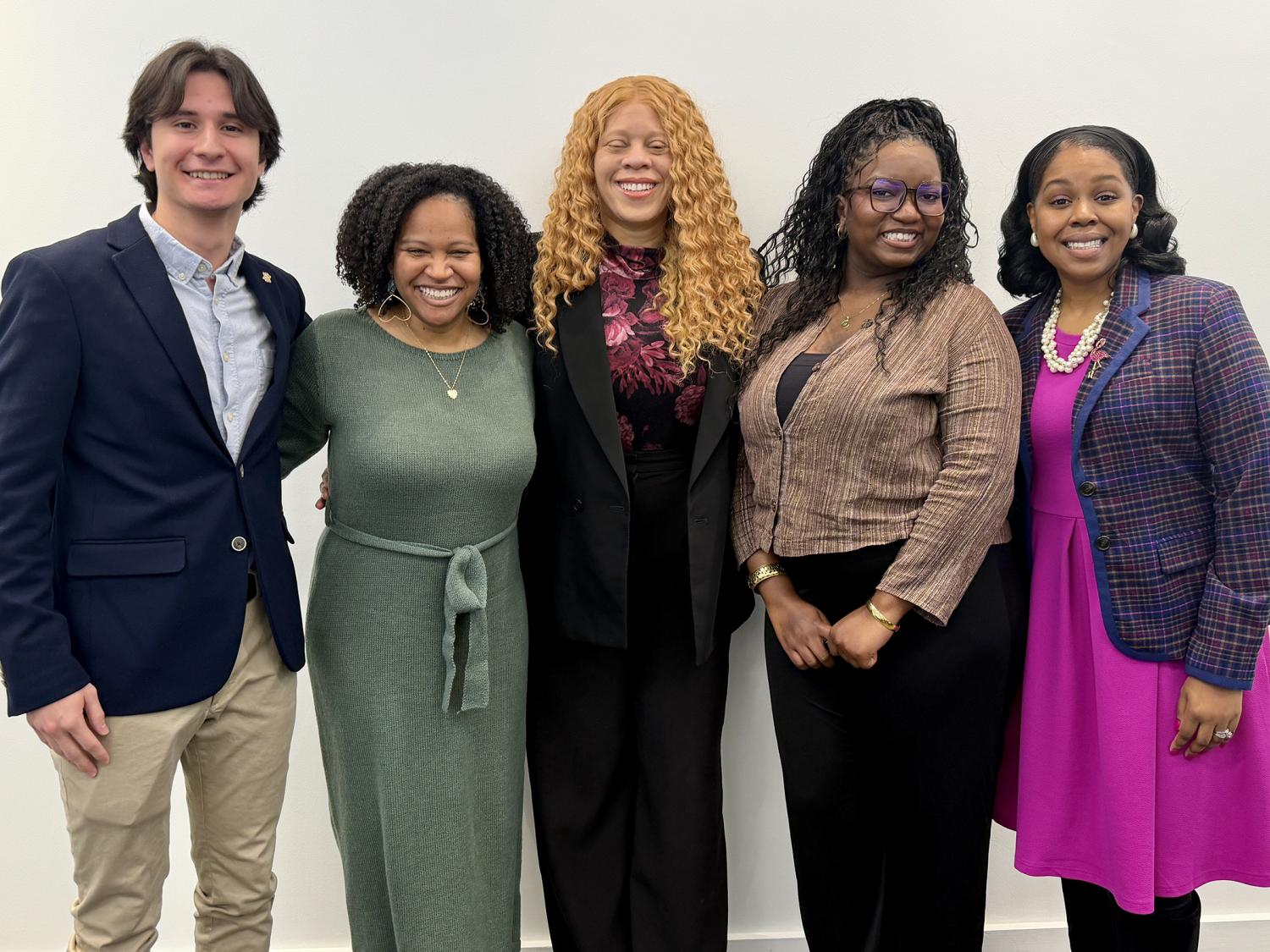 Five people smile for the camera