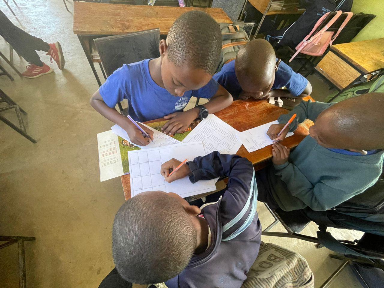students fill out worksheets in Tanzanian classroom