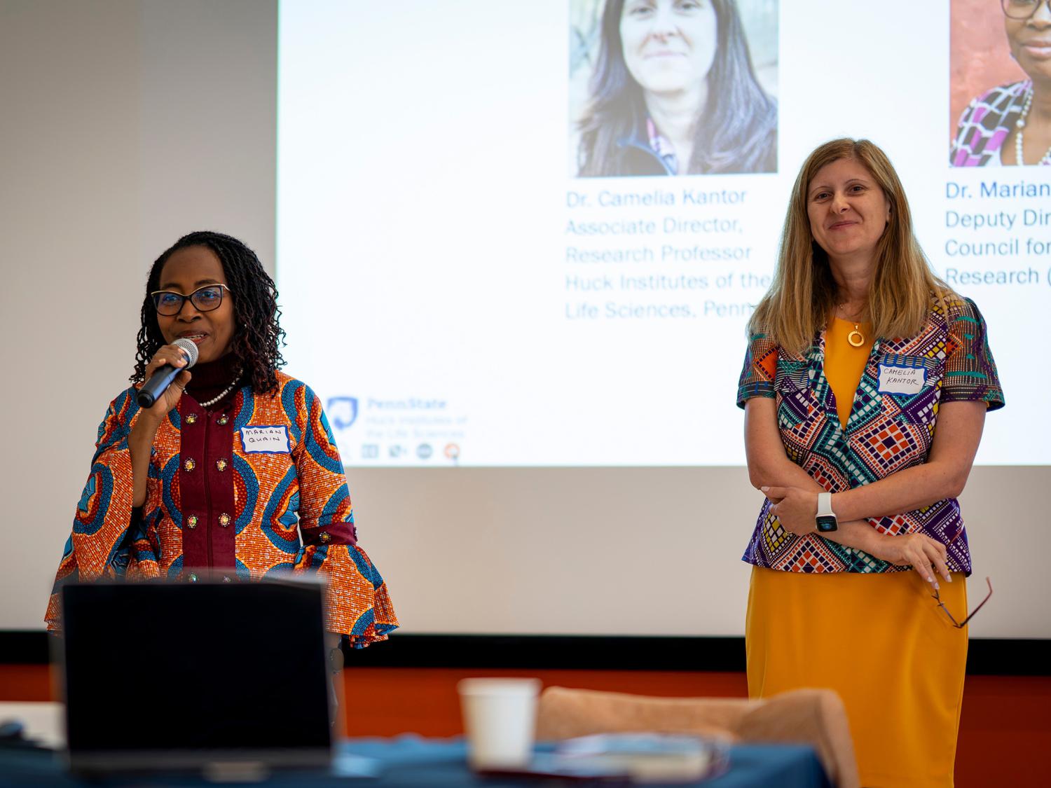 Two women standing in front of a projector screen