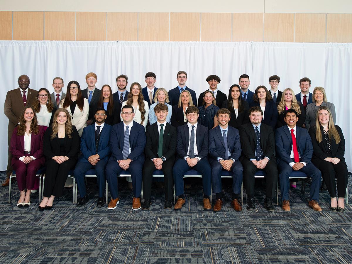 A group of Penn State Altoona students and staff pose for a formal portrait, dressed in business attire as part of the Sheetz Fellows program.