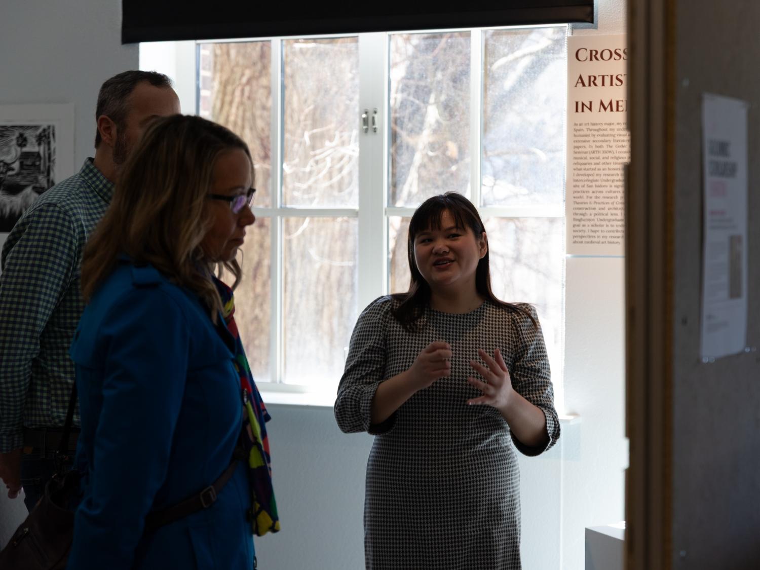 A student explains her project in an exhibition.
