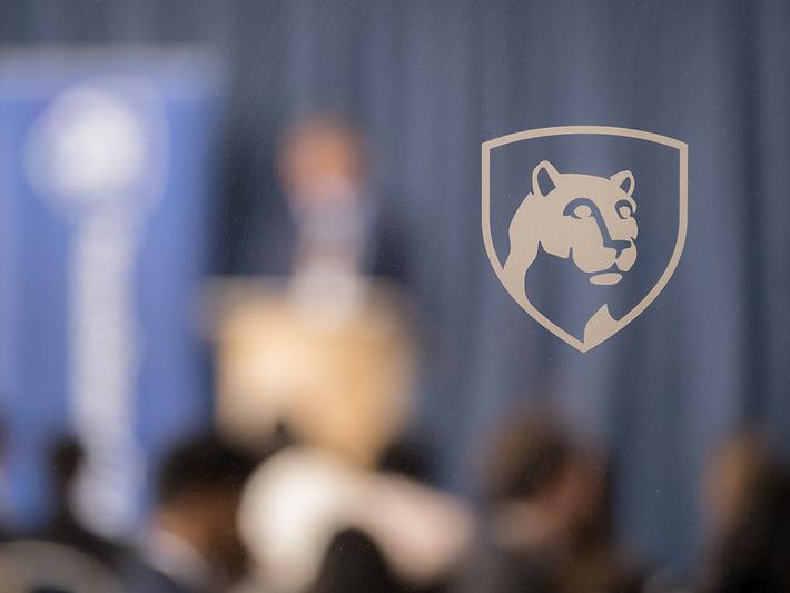An image of the Penn State shield superimposed on a blurred background
