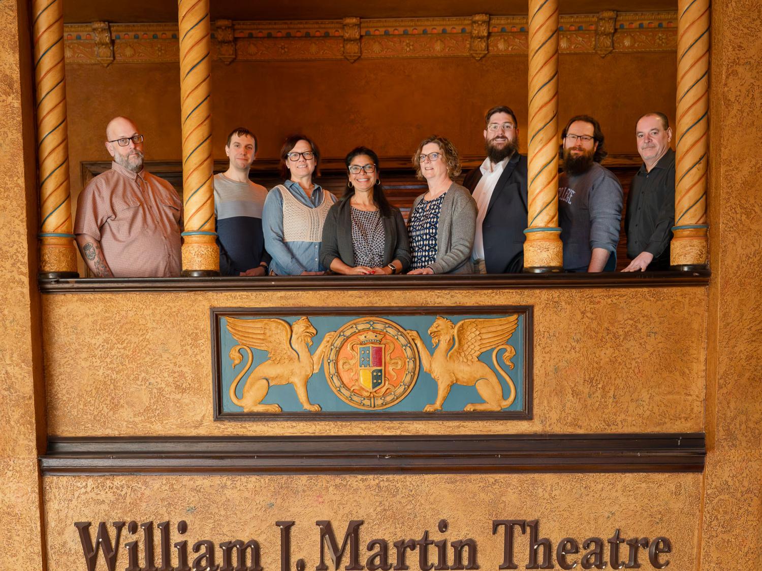 A group of people lined up in the balcony with a sign that says William J. Martin Theatre