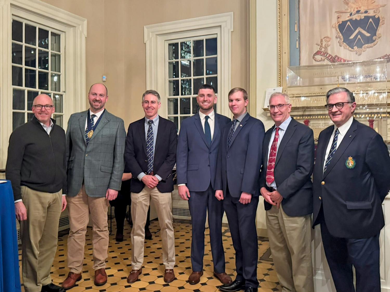 A group of people pose for a photograph wearing business suits