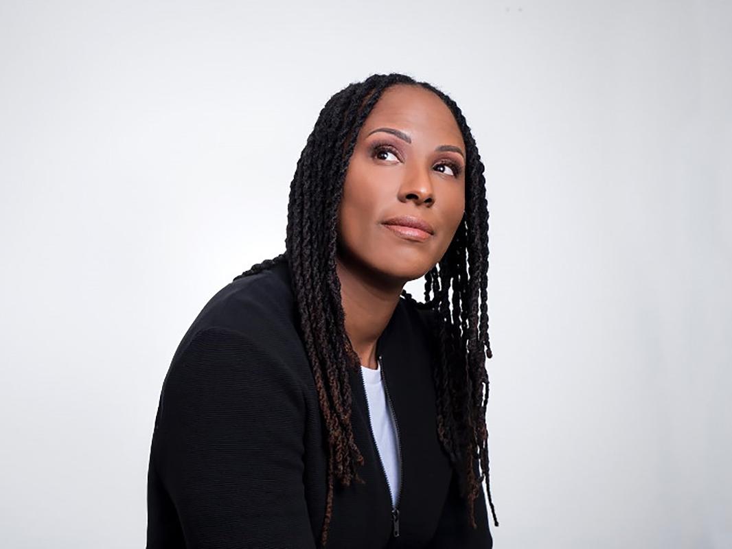 Chamique Holdsclaw wearing black jacket staring upward to her right 