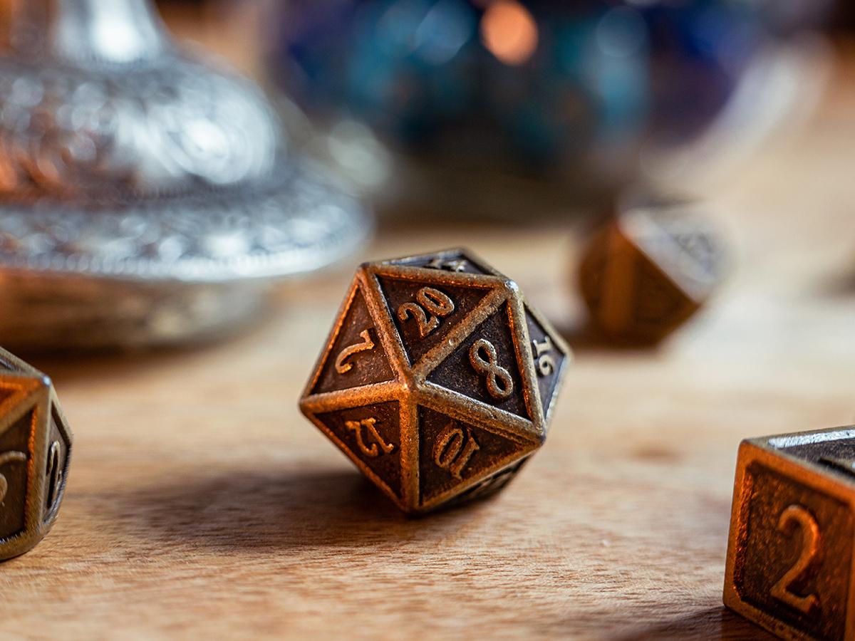 A 20-sided die sits on a tabletop among other tabletop gaming dice, commonly used in role-playing games like Dungeons & Dragons.