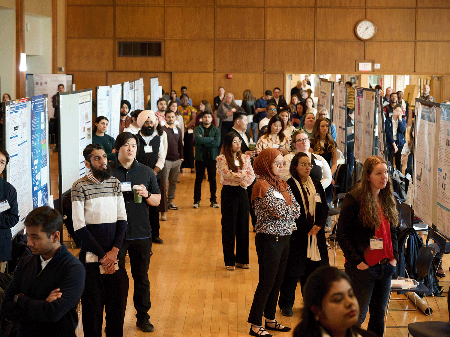 2025 Graduate Exhibition participants wait for the event to begin in front of their research posters