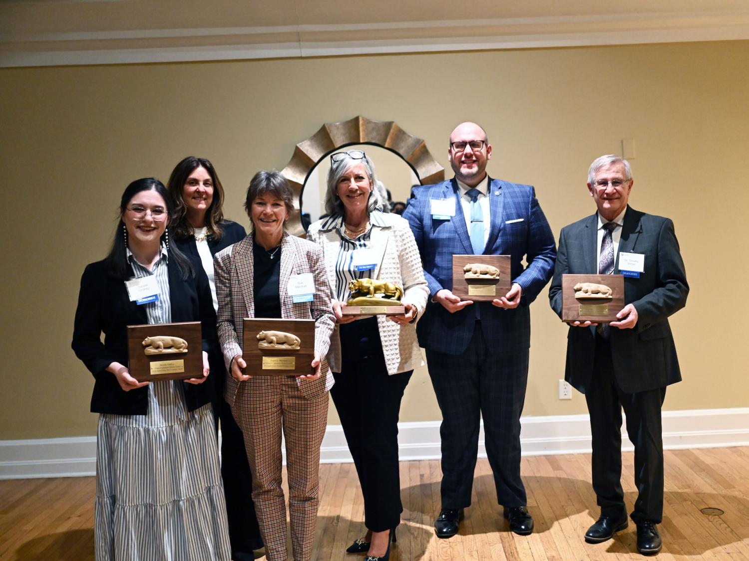  Six individuals stand together indoors, five holding Penn State College of Education alumni award plaques. The group includes the 2026 award recipients alongside Susan Land, associate dean of undergraduate and graduate education, who represented the college at the ceremony.
