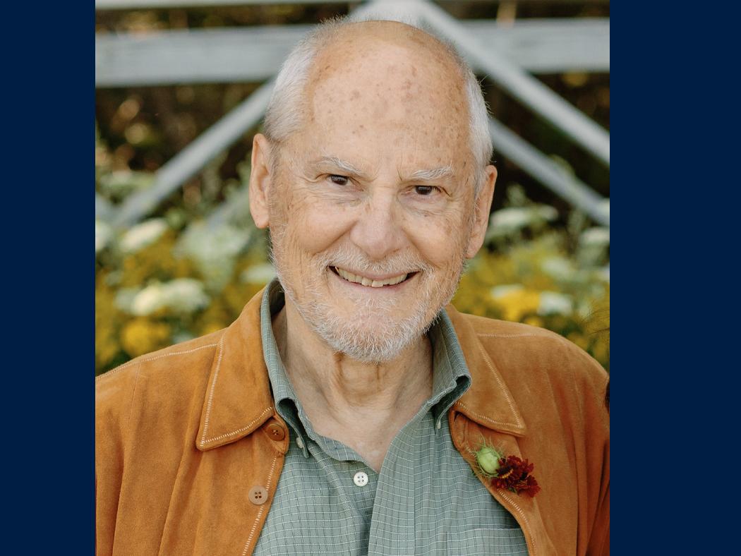 Headshot of older man with minimal white hair and sparse gray beard