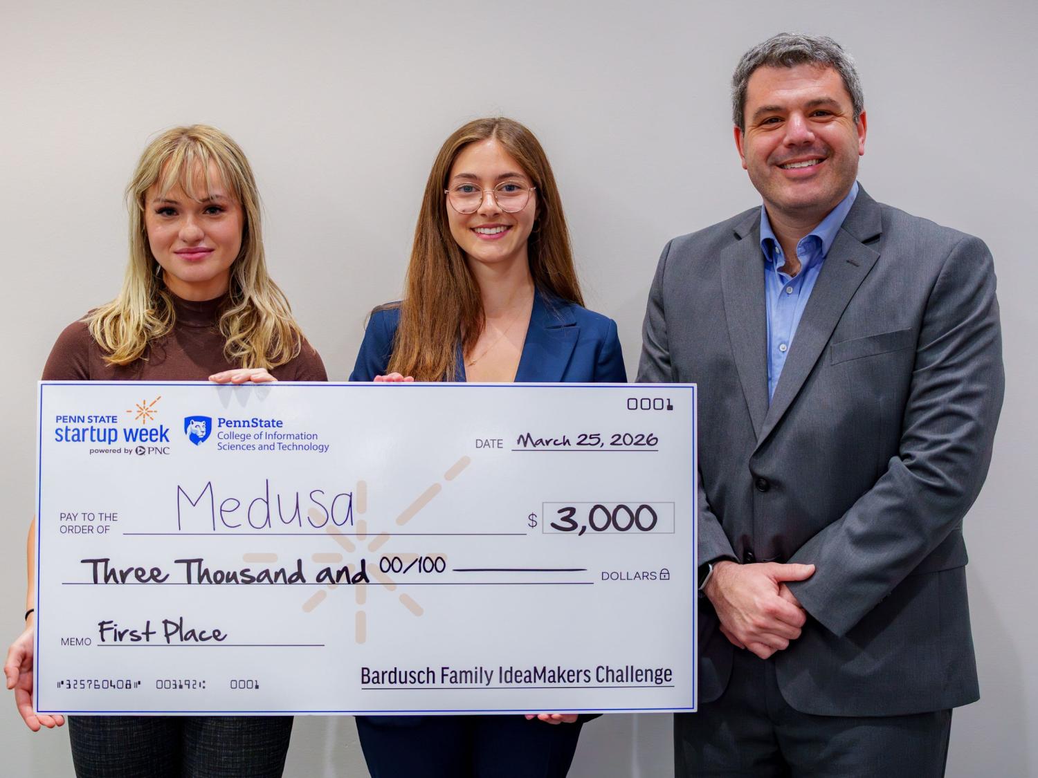three people holding giant check