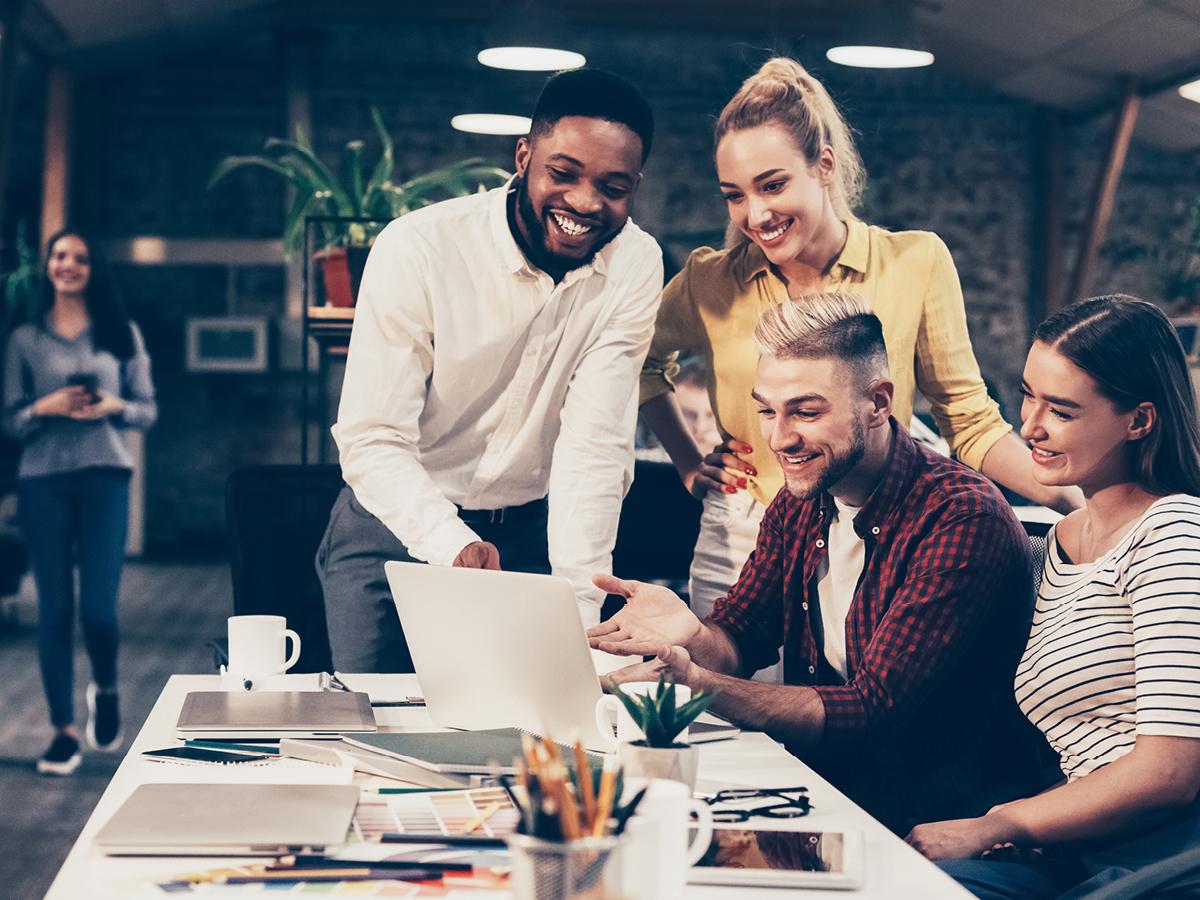 Group of students. Two are standing and two are seated around table.