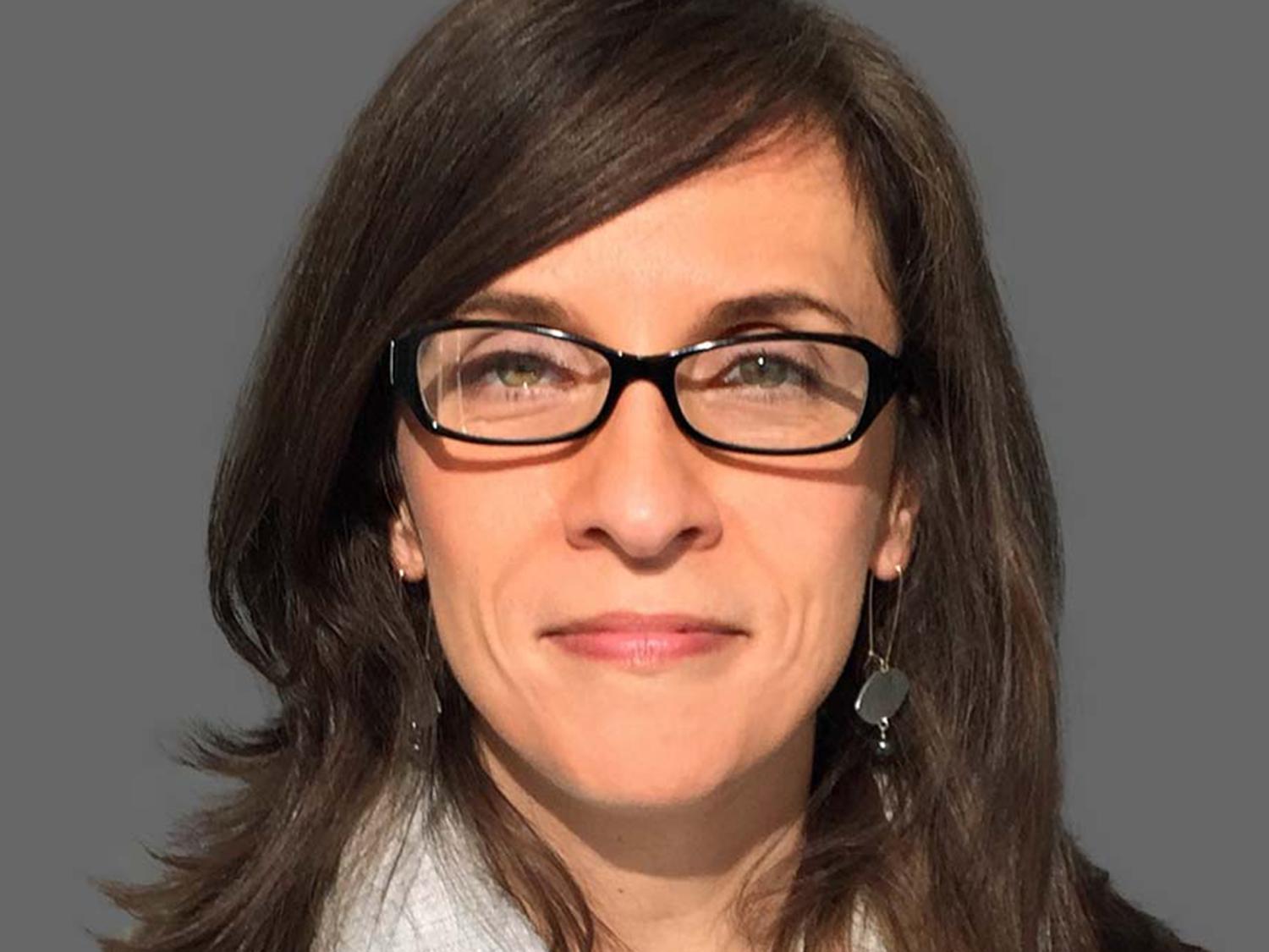 Smiling woman with dark hair and dark glasses