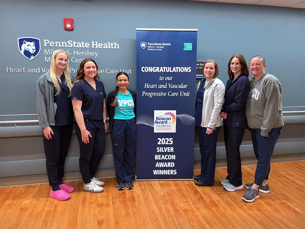 Six people pose around a sign that says, "Congratulations to our Heart and Vascular Progressive Care Unit 2025 Silver Beacon Award Winners."
