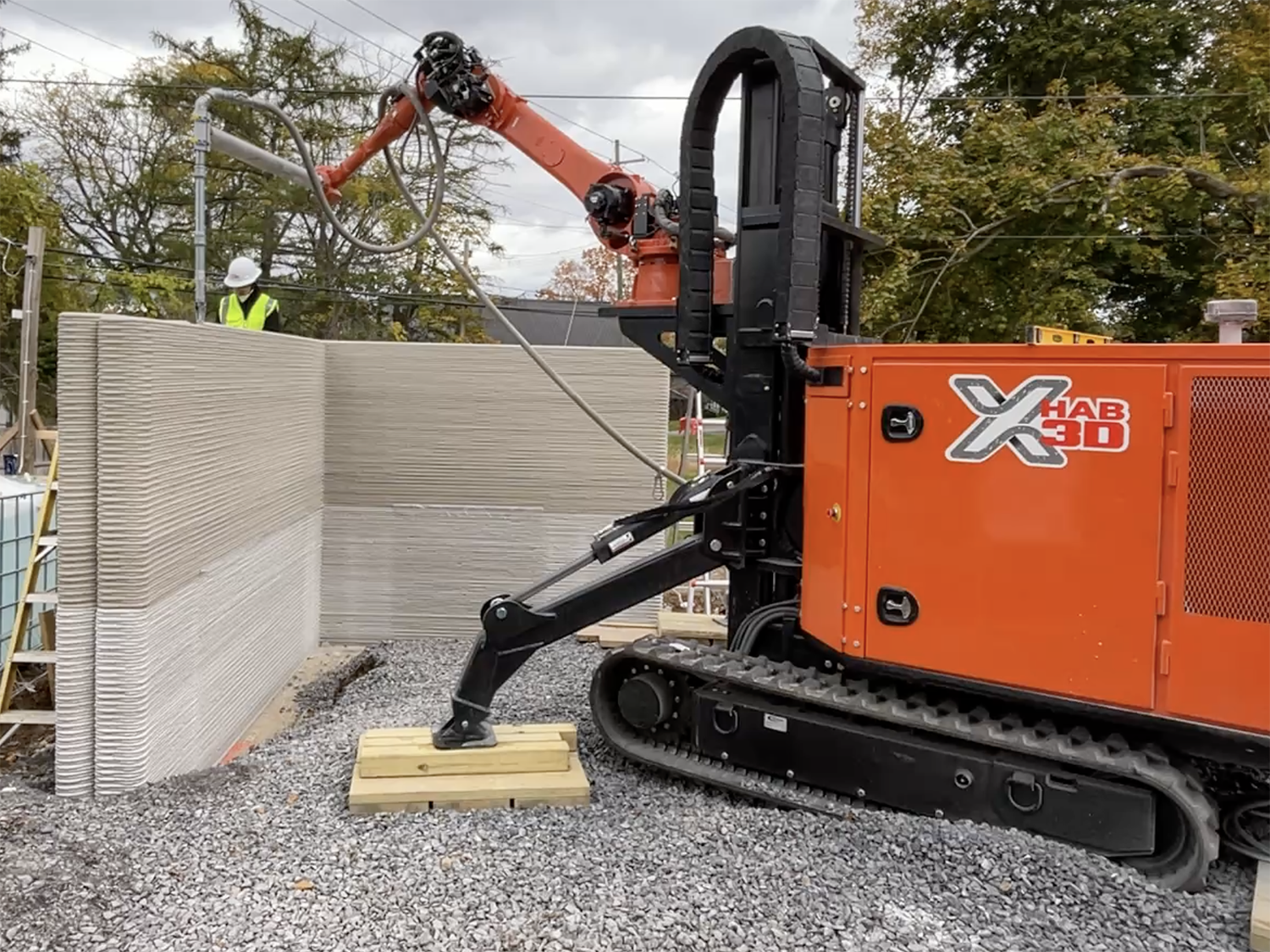 A photo of an X-Hab 3D machine printing a wall of a new structure.
