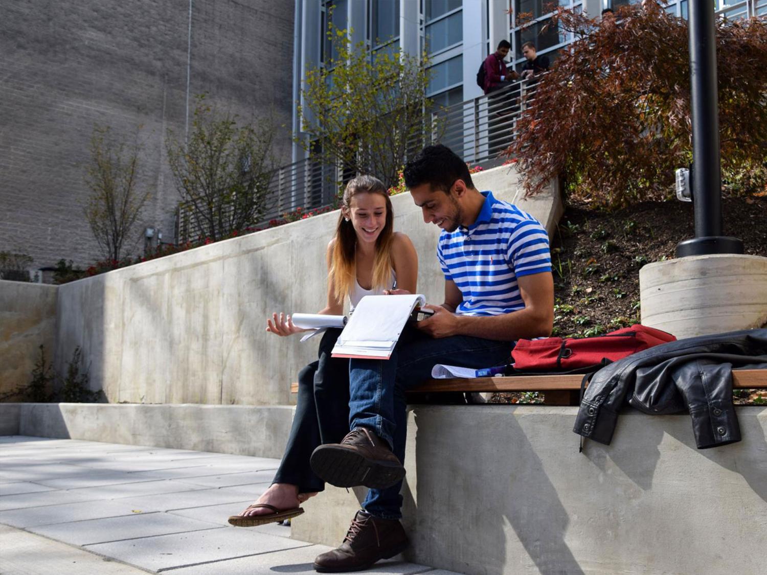 two people sitting outside and studying
