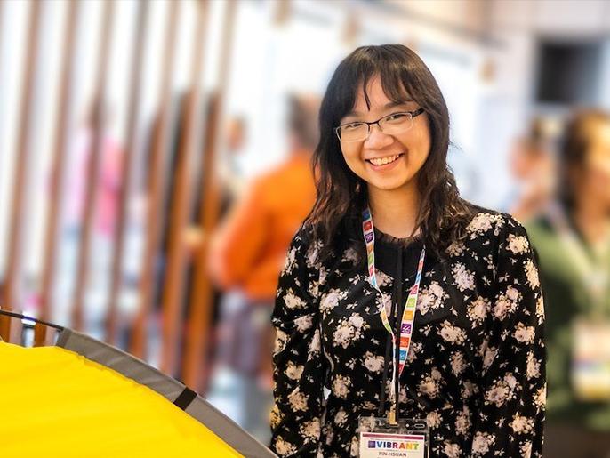 Asian woman with short dark hair and glasses posing and smiling