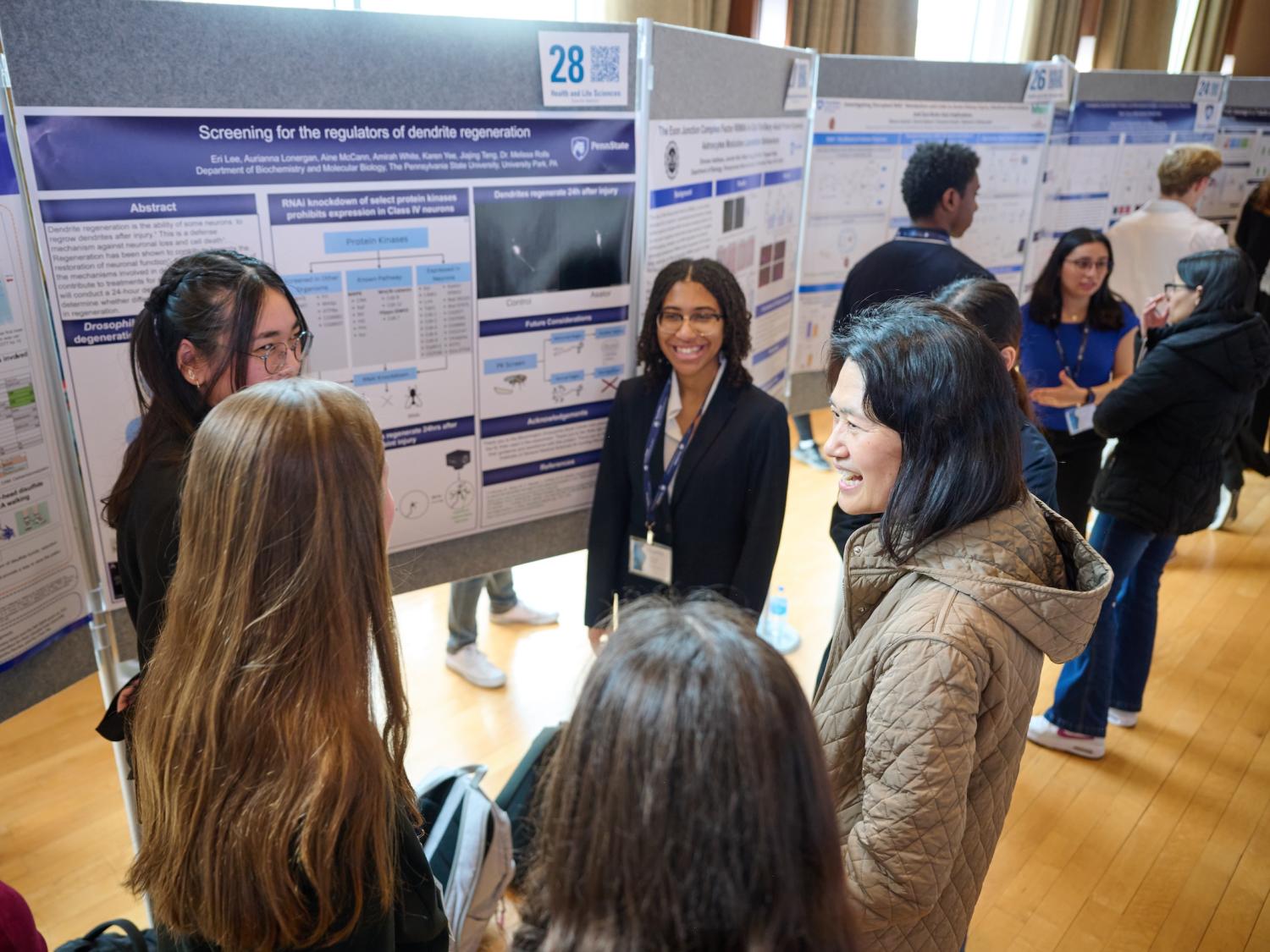 Students in group presenting research poster to faculty judge