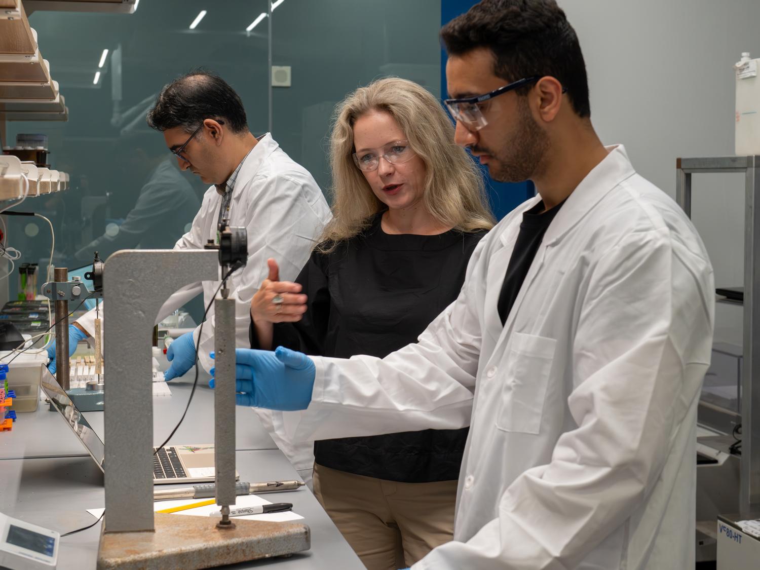 Three researchers looking over a project in their lab.