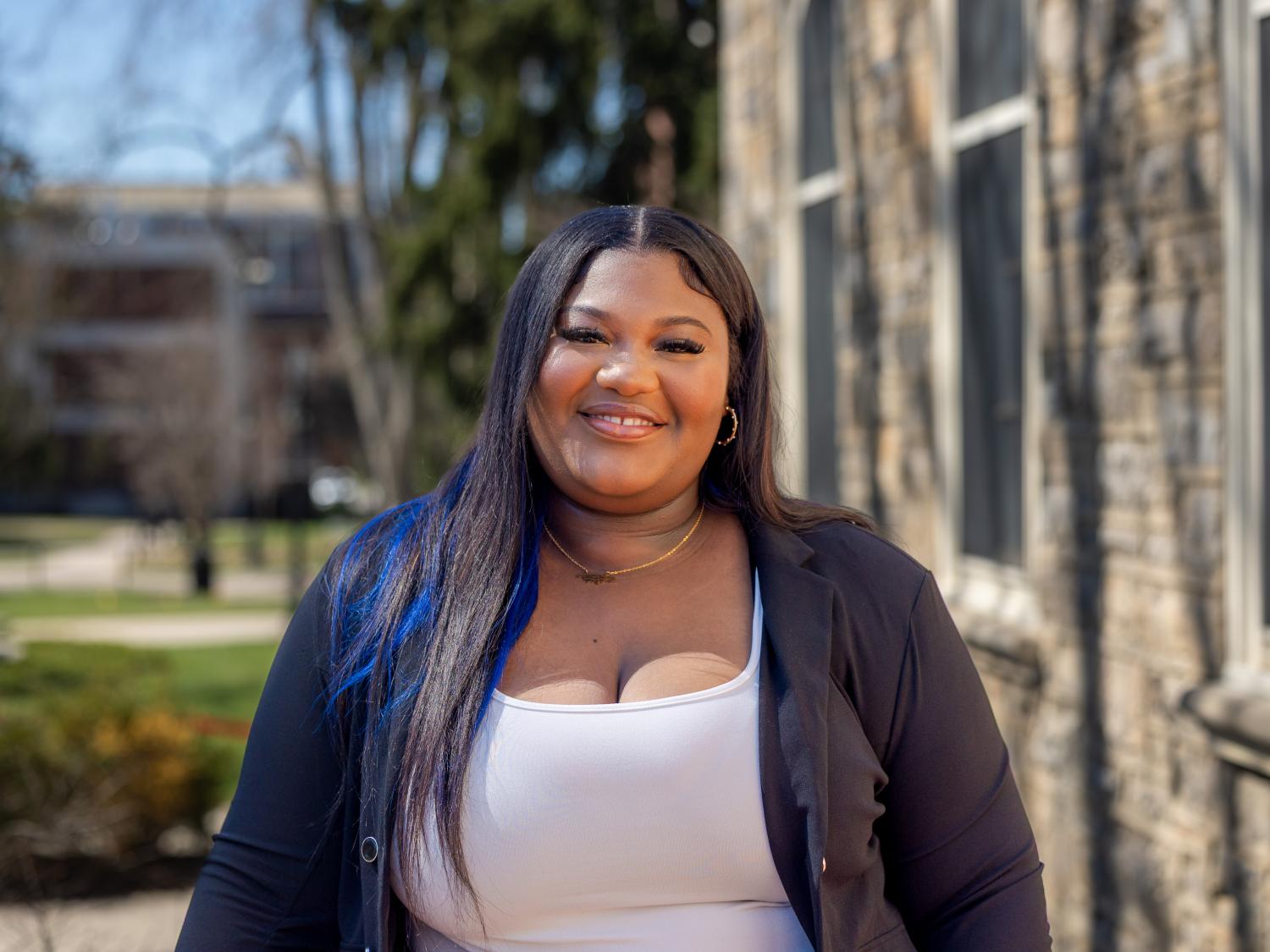 Shaquana Simpson stands outside Old Main Building on a sunny day.