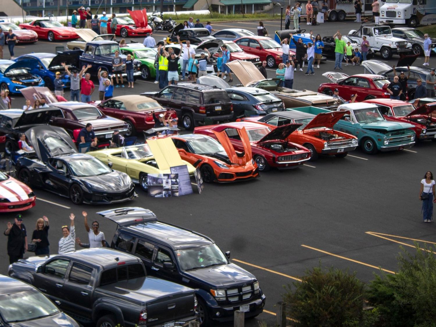 dozens of cars with hoods propped open in the Penn State scranton parking lot for a fall car show