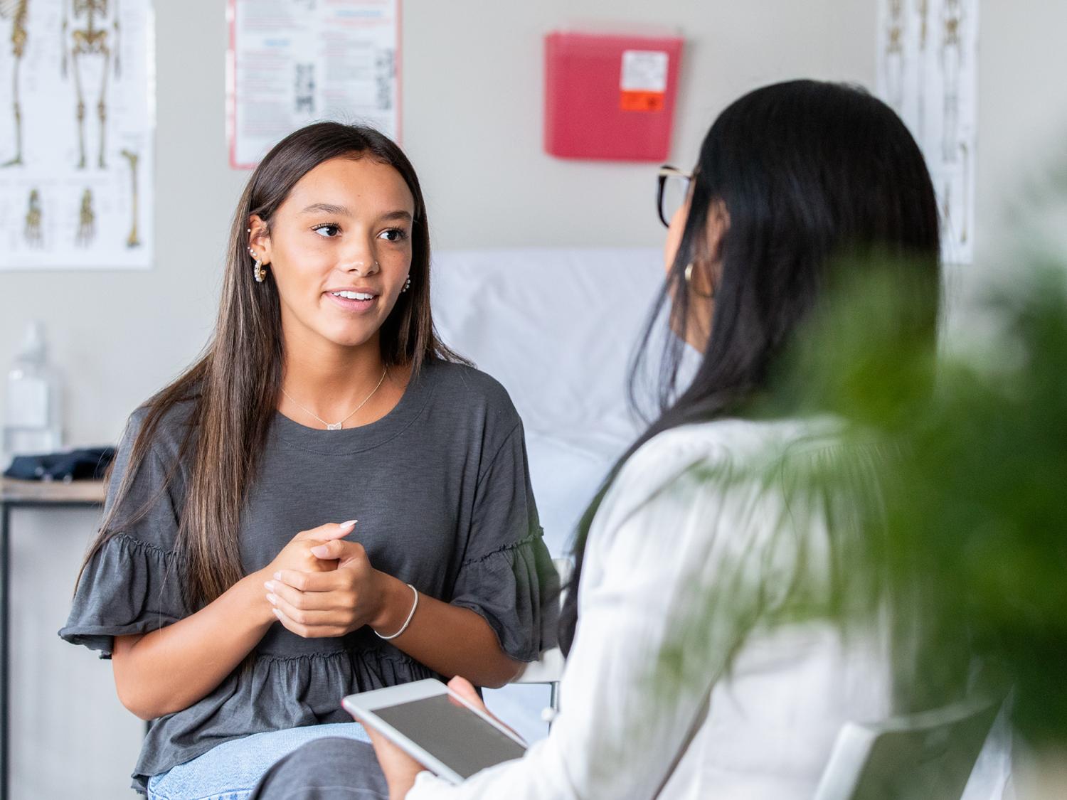teen talking to doctor in office