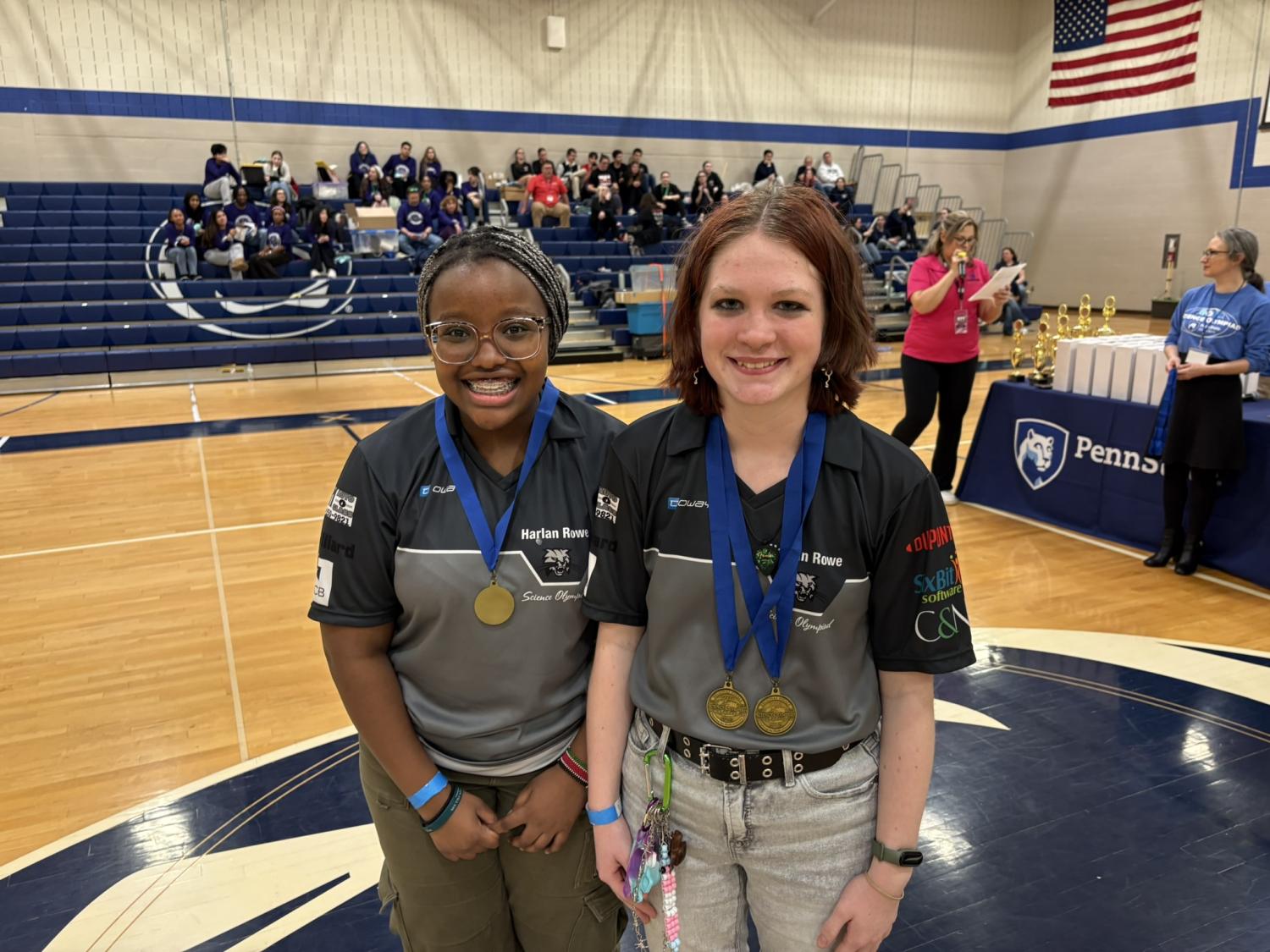 Two middle school students smiling with their Science Olympiad medals