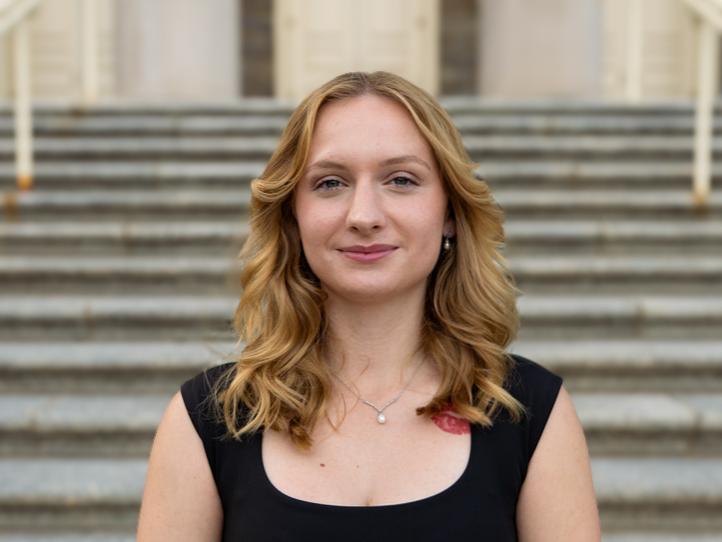 Laenee McCoy stands outside Old Main smiling wearing a black top.